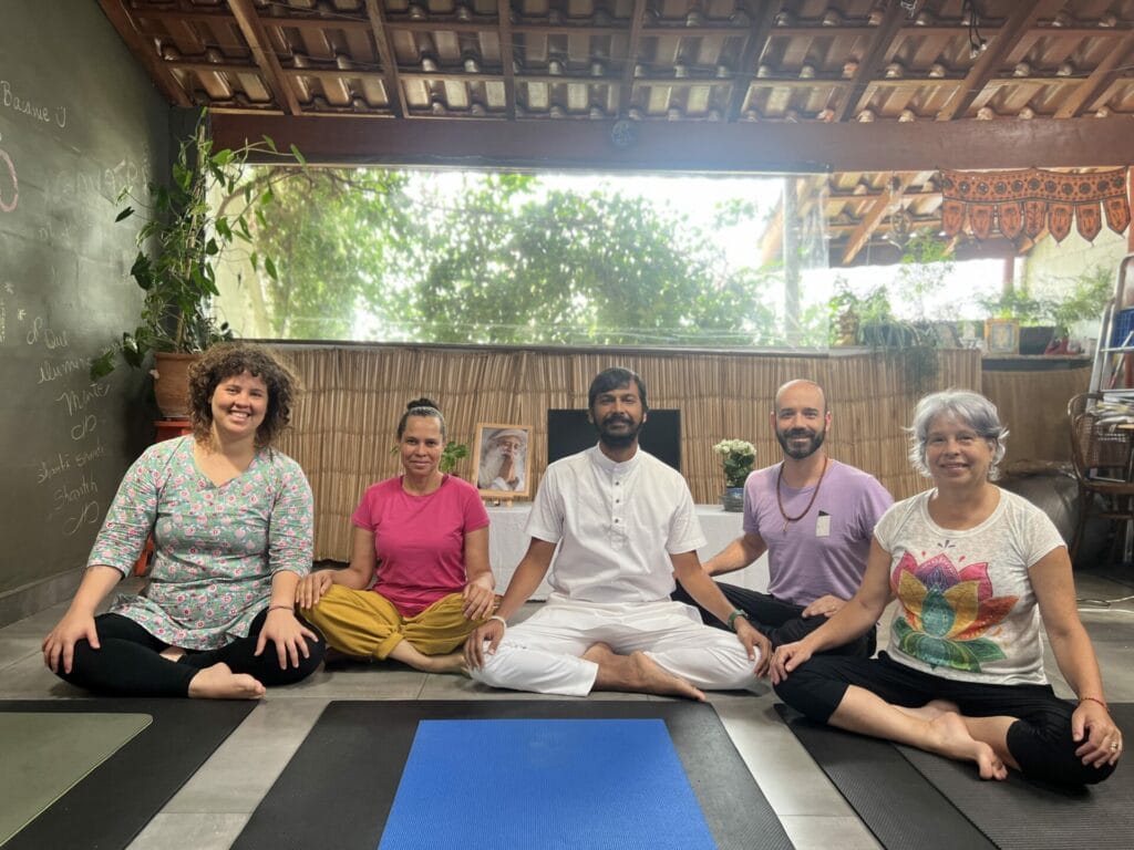 A group of people sitting on yoga mats in a room.