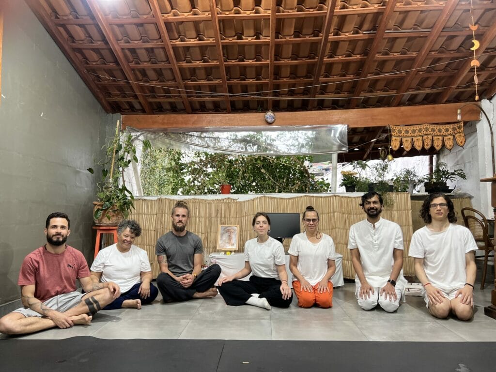 A group of people posing for a photo in a yoga studio.
