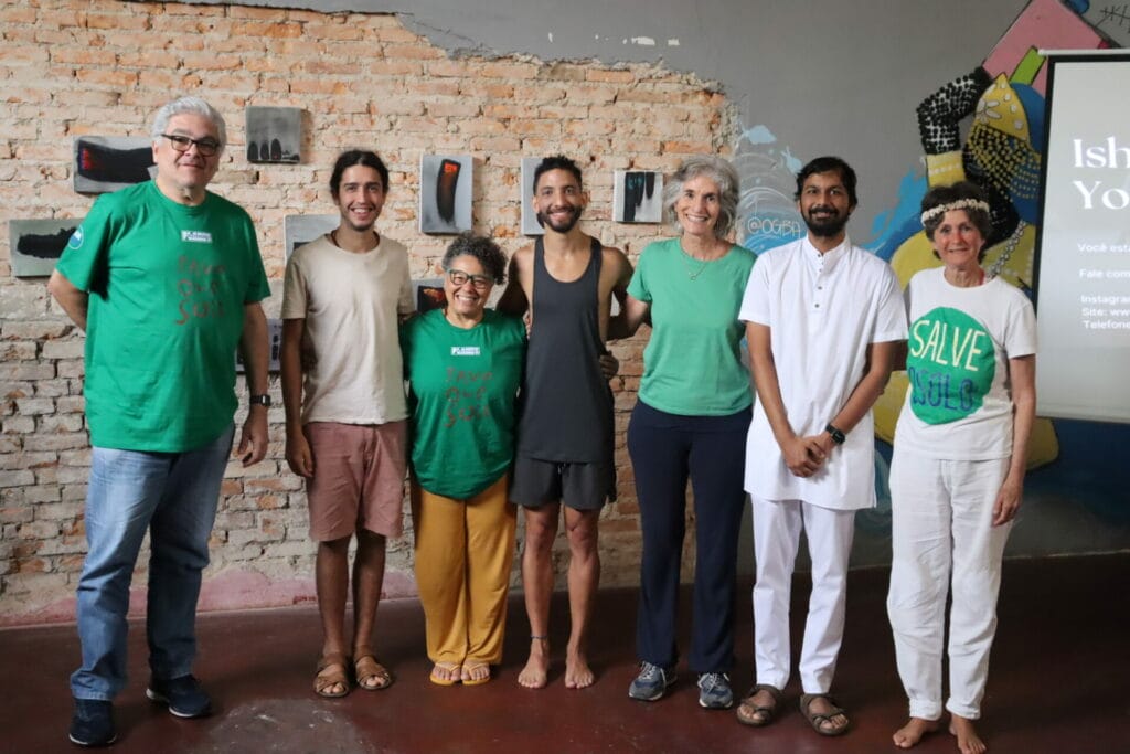 A group of people in green t - shirts standing in front of a wall.