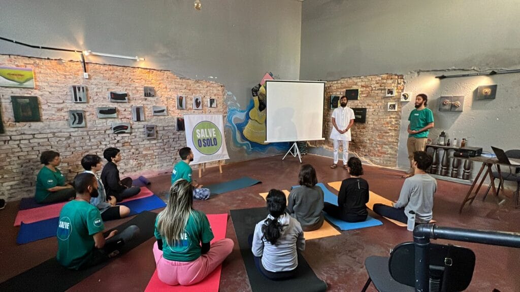 A group of people sitting on yoga mats in a room.